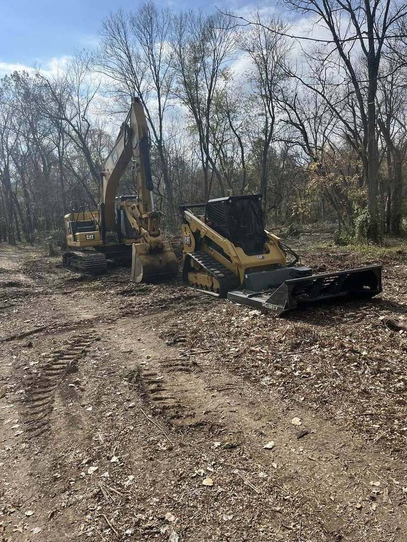 Moore Contracting excavator with brush cutter clearing a wooded fence row